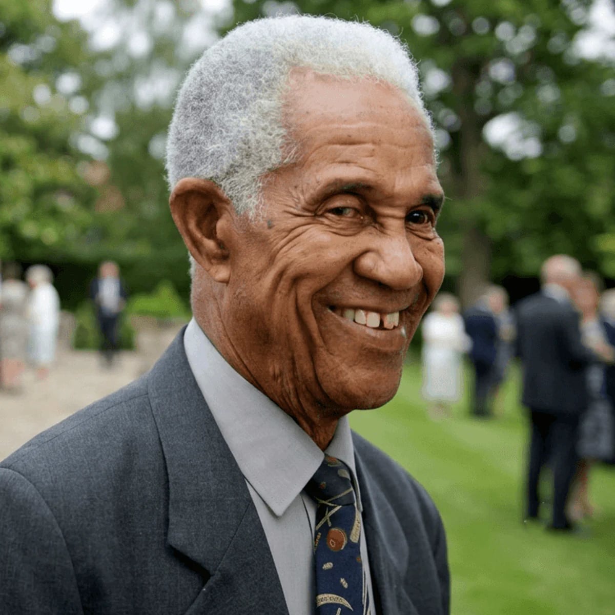 Sir Garry Sobers smiling at an outdoor gathering later in life.