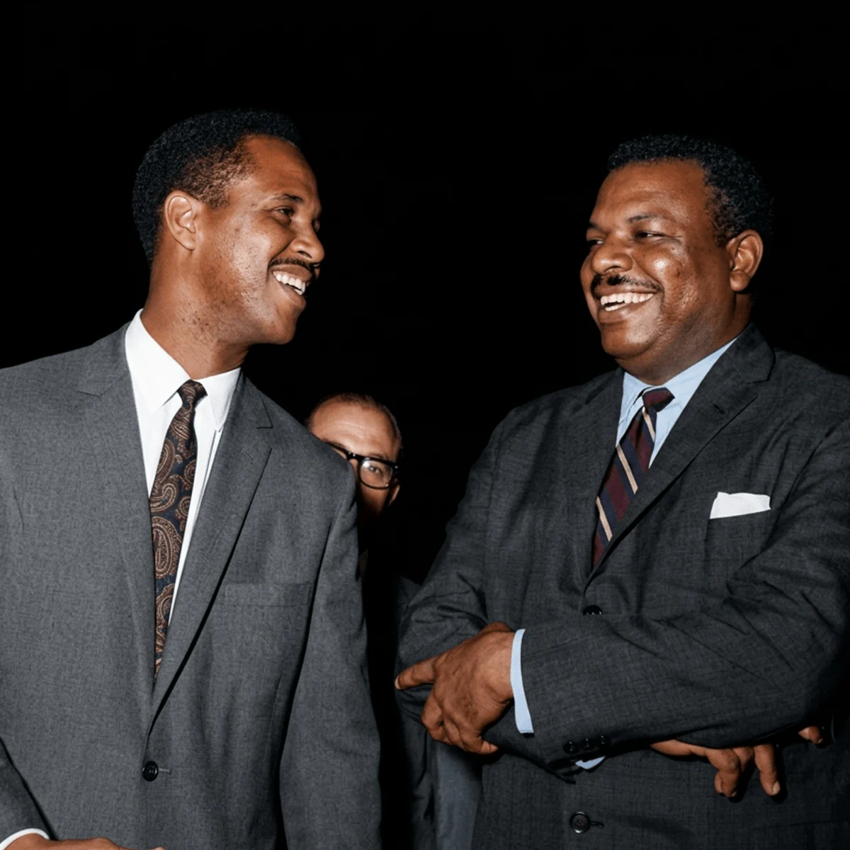 Sir Garry Sobers sharing a laugh with another man at a formal gathering.